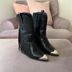 Cowboy boots - Svarta cowboy boots med fransar och silver längst fram vid spetsen. Så coola! Jättebra skick. Köpta på butiken Two Angels, tror märket kan vara Pavement. Stl 36 (passar även liten 37).🖤