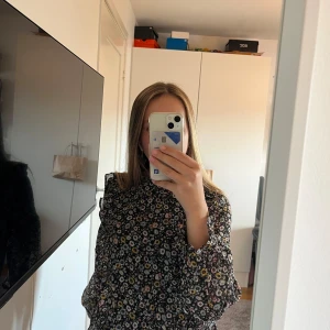 Blus - Säljer denna söta blusen! Den har ett blommigt mönster med lite volanger. Dubbel tyg i tröjan, se bild 3. Tunnare material i armen. Hör av er vid frågor eller fler bilder!!  Pris går att diskutera💓