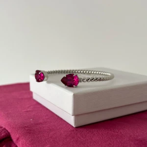 Nytt Caroline Svedbom armband  - Nytt armband från Caroline Svedbom i modellen Mini Drop. Oanvänt, i ny/utmärk skick. Storleken kan justeras för att passa just din handled. Storlek: Justerbar från 55 - 70 mm Plätering: Rodium. Stenfärg: Fuchsia/ mörkrosa. Ask medföljer. Nypris 795 