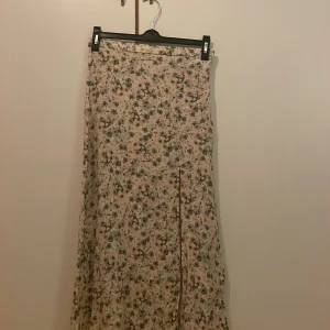 Blommig kjol  - Använd varsamt några gånger. Storlek 36 men är själv S/34 och skulle säga att kjolen passar om du är xs då den har blivit lite mindre i midjan vid tvätt.