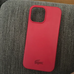 Skal Iphone 13 pro Max  - Ett silkonskal från Lacoste, bara en liten skada på sidan 