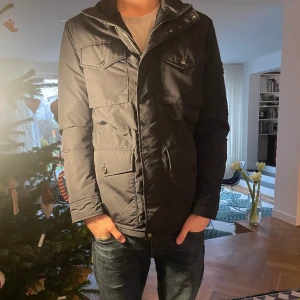 J. Linderberg övergångsjacka - En helt ny J.Lindeberg övergångsjacka med taggen kvar, funkar perfekt till alla årstider. Den är i storlek S men sitter som en M. Den är såklart äkta och det är bara att meddela kring minsta lilla fråga.