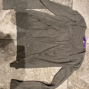 Tröja stl.Xs - Grå tröja i jättefint skick. Inte så mycket använd. Jättefina knappar, rosliknande. Säljes pga stor garderobrensning. Kika gärna på mina andra annonser, säljer mycket. Samfraktar gärna:)