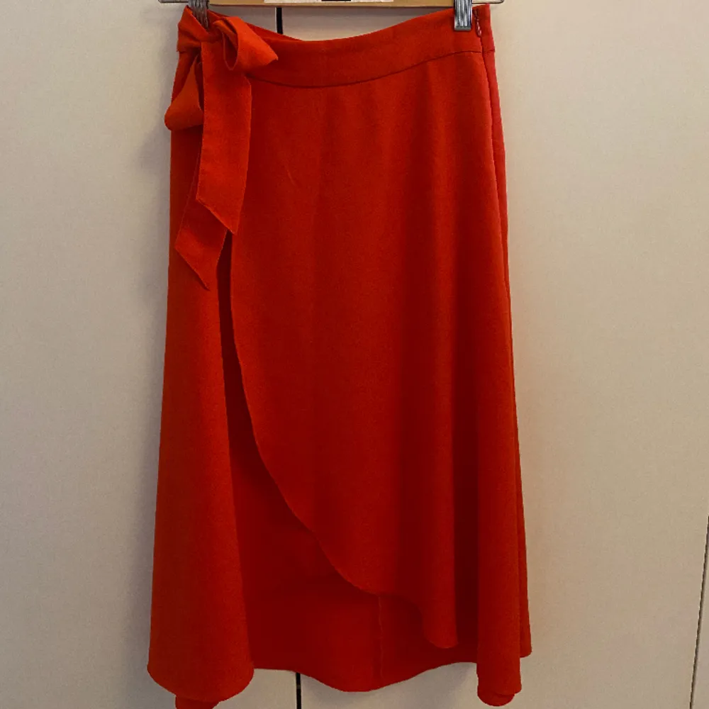 Röd omlott kjol med en fin knytning från Monki. Har bara använts några få gånger och är precis som i nyskick. Den är i storlek 32 och oridinariepriset var 299kr. Sldrig vid frågor!❤️. Kjolar.