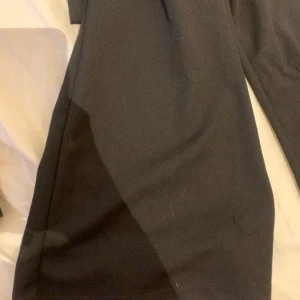 Svarta byxor  - Svarta byxor med lite öppning  på sidan av midjan och utsvängda längst ner från NewYorker