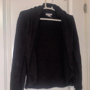Svart ribbstickad cardigan - Ribbstickad svart cardigan. Bekvämt och värmande material. Mycket bra skick. Storlek XS, från H&M. 