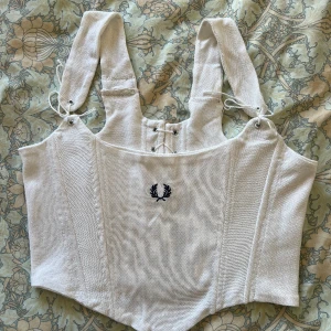 Upcycled Fred Perry-korsett - En helt otrolig upcycled Fred Perry-korsett, skapad av en av deras ikoniska tröjor. Köpte den av en tjej som skapar dem själv men tyvärr var den lite för stor för mig så nu säljer jag den till någon som älskar den lika mycket som jag. ❣️