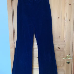 Blå utsvängda manchesterbyxor  - Blå manchesterbyxor med utsvängda ben. Verkar vara hemsydda. Jättefint skick. Längd 101cm, finns ca 2-3cm fåll att lägga ned Längd midja - gren 32cm Midja 34cm Höft/stuss 47cm Innerben 72cm