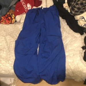 Blåa parachute pants  - Bra skick, använda typ en gång. Man kan justera midjan och längst ner. Säljer för dom e för stora. 