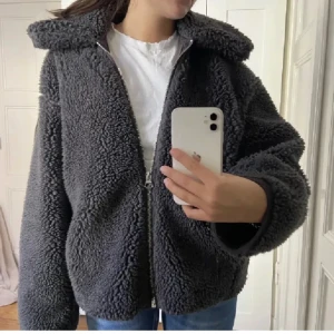 Grå teddyjacka - Grå teddyjacka från Weekday. Köpt på plick men aldrig använd, hon hade ba använt fåtal gånger så den är som nyskick. Priset kan nog diskuteras!