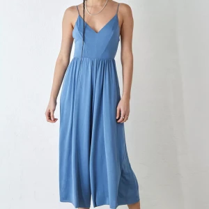 Blå byxdress öppen rygg - Köpt för ca två år sedan, är i bra skick och använd endast en gång🌟köpt från Urban Outfitters för 600kr. Är en byxdress men ser ut som än klänning pga breda ben