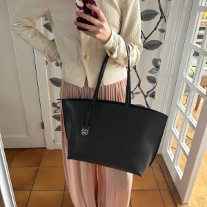 Shopper - Shopperväska i styvt material med dubbla handtag och kedja upptill. Ett innerfack med dragkedja. Fint skick. Nypris är 349kr, säljer för 175.