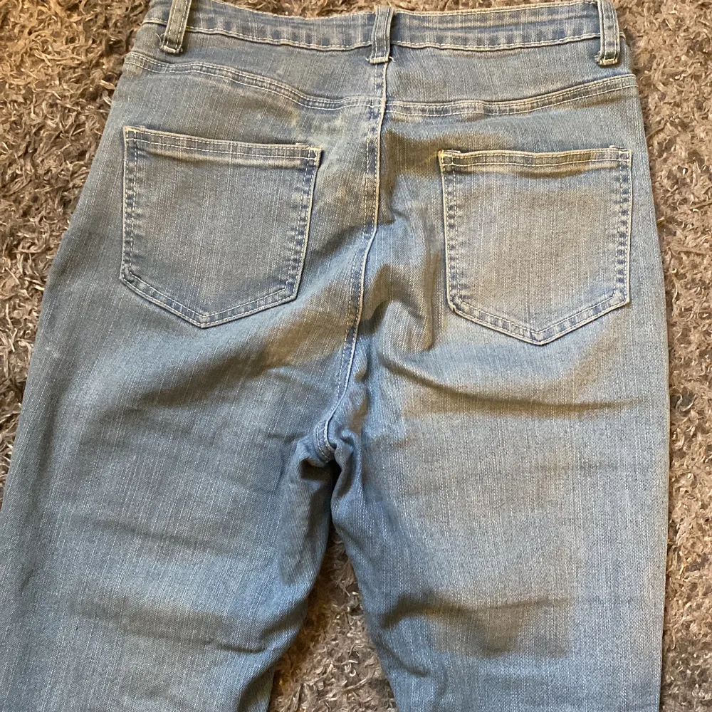 Ljusblå bootcut jeans i stretchigt tyg och med ofållade benslut. Passar storlek S-M.. Jeans & Byxor.