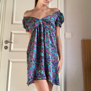 Klänning  - Helt ny klänning med färgglada blommor🫶🏼 Man kan ha den vanligt vid axlarna som på första bilden eller off shoulder som på andra.  Verkligen jättefina detaljer! (puffig i ärmarna) Köpt från märket Lipsy London som inte längre säljer denna klänning🌟
