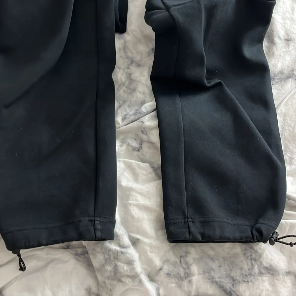 Ett par svarta Nike tech byxor i storleken S. De är i ganska bra skick. . Jeans & Byxor.