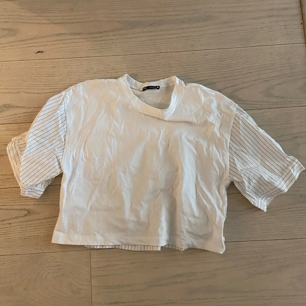 En vit t-shirt med en blandning av skjorta på ärmarna. Den är använd en gång och säljer den just för att den inte kommer till användning . T-shirts.