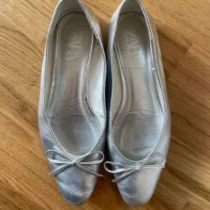 Så fina ballerinaskor i silver från Zara. Storlek 38. 100% läder. Endast använda 2-3 gånger av mig så är i fint skick men finns ett litet skav i färgen (se bild). 
