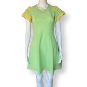 Pastel vintage klänning i fint skick! Genomskinligt material. MÅTT: Axel till axel 31cm, ärmlängd 16cm, armhåla till armhåla 39/40cm, midjebredd 34cm & längd 86cm