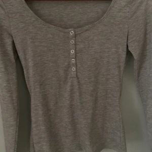 grå långärmad tröja från shein med knappar   - sitter tajt i midjan och är en jätte fin basic tröja 🙏