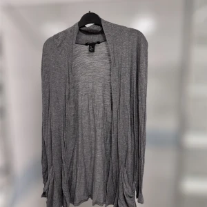 Tunn kofta - Jättefin grå lång kofta som är tunn från hm i storlek S. Den är skön och perfekt till sommarkvällar när det kan bli liiiite kyligare men inte tillräckligt kallt för en tjocktröja!!  