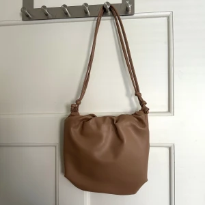 Brun väska  - Brun väska från Vero Moda. Jättefint skick endast använd 2 gånger! Längden går att justera väldigt mycket så man ha den  crossover om man vill🤎