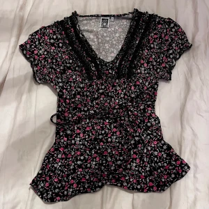 Blommig tröja  - Snören så man kan knyta till för fin midjemarkering. Blommig och väldigt söt.  Skriv om ni har någon fråga, svarar så snabbt jag ser de! ❤️