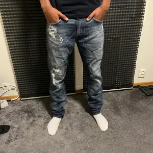 Säljer dessa tiger of Sweden jeans skicket på byxorna är 10/10 och är slim fit. Slitningarna är en del av modellen. 