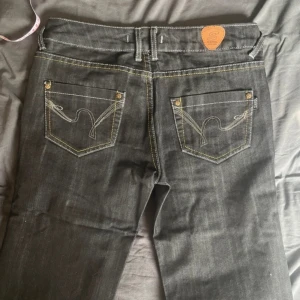 gråa jeans  - lågmidjade utsvängda grå/ svarta jeans, skulle säga att de passar 34/36 xs