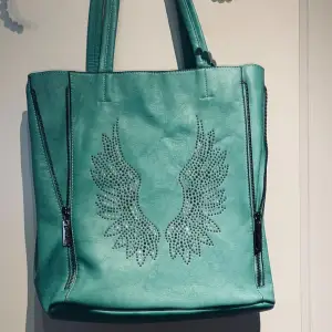 Det här är en stor turkos väska med paljetter formade till ängelvingar och en matchande nessesär i samma färg👼👜. Väskan har ett gott skick, köpte även denna dyrt runt 600kr.💕💕