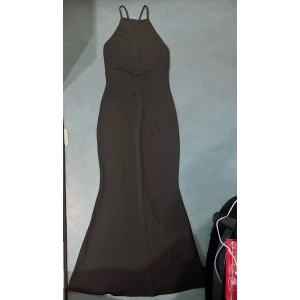 Svart klänning  - Stretchig svart klänning med öppen rygg. Använd endast en gång. Fråga på dm för bild om hur den sitter från hemsidan.  