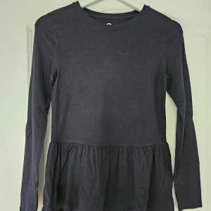 Svart basic tröja med volanger  - Perfekt basplagg i svart! Volanger och otroligt skönt material. Fint skick! 🌟