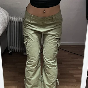Lågmidjade militärgröna cargo byxor - Aldrig använda, bra skicka (lite skrynkliga på bilden men inte ngt ett strykjärn inte kan fixa). 