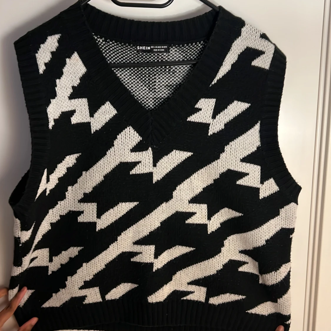 En stickad tröja som är randig svart och vit  - 91