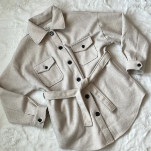 Vårjacka - En jättefin beige jacka ifrån Nelly i storlek 32/Xxs men skulle säga att den är mer som 36/S. Den är använd några gånger, väldigt bra skick, inga defekter. Nypris 699 :-