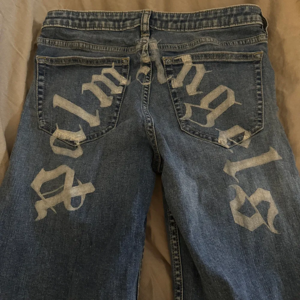 Målade utsväng jeans med palmangels text bak till. Storlek 26 passar xs-s beroende hur man vill att de ska sitta. Färgen klarar tvätt. . Jeans & Byxor.
