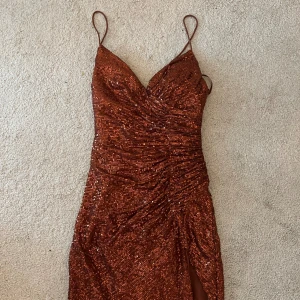 Glittrig balklänning  - Jätte fin balklänning som jag hade förra året. Även köpt förra året från lady black tie. Rekommenderar att köpa den från mig och inte från hemsidan då tullen landade på runt 2000. Den har absolut inga defekter då den endast är använd en gång.