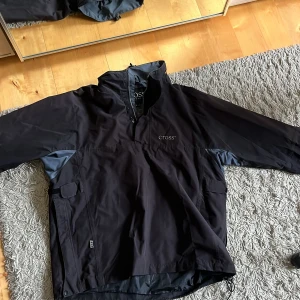 Vindjacka - Svart vindjacka. Fler öppningar på sidorna och i halsen. Lufthål i armhålorna. Kardborreband vid ärmarna och armhålorna. Ingen luva. En liten defekt. Perfekt i stallet eller utomhus. Pris diskuterbart ❤️🤗🥰
