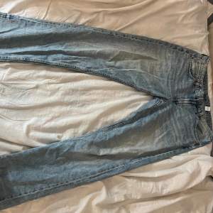 Blå raka lågmidjade jeans i storlek 42 från H&M. De har hål som ska vara där förrutom ett vid benet som syns på bilden.