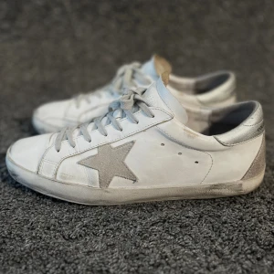 Golden Goose  - Golden goose skor i den eftertraktade färgen vit/grå. Storlek 43. Fint skick, de ska se slitna ut från början. Inget og medföljer, därav pris🤝 Nypris 4599kr, köp för 2399kr.