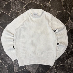 Vailent Stickad Tröja - Säljer en fräsch vit stickad tröja från Vailent i storlek S. Tröjan har ett ribbat mönster och rund hals, perfekt för dig som gillar enkel och clean stil. Långärmad och mjuk, passar när du vill vara både chill och snygg.