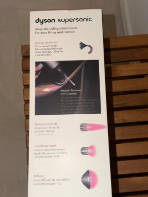 Dyson Supersonic - Dyson Supersonic hårfön i blå/guld, levereras i originalförpackning. Snabb torkning utan extrem värme, skyddar hårets naturliga glans och passar olika hårtyper. Inga synliga defekter eller slitage, är helt ny. Perfekt för kontrollerad styling med fem medföljande tillbehör.