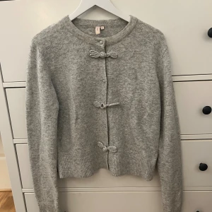 Grå kofta med rosettknäppning - Superfin grå kofta med rosettknäppningar framtill.