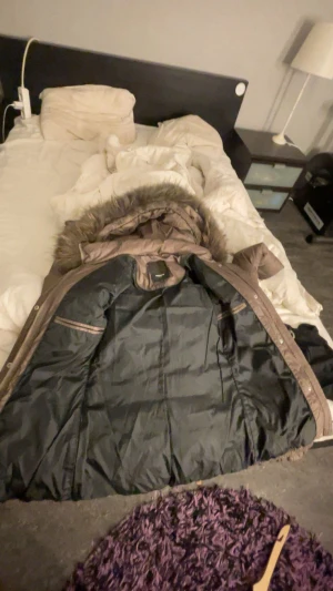 Brun quiltad dunjacka med pälsluva - Säljer en brun dunjacka från Rockandblue med quiltad design och stor fluffig päls på luvan. Jackan har dragkedja och knappar framtill, samt praktiska fickor med dragkedja. Perfekt för dig som vill ha en varm och snygg jacka med coola detaljer, den har varit använd några gånger men den är jätte bra ändå! Inga hål eller skador. 