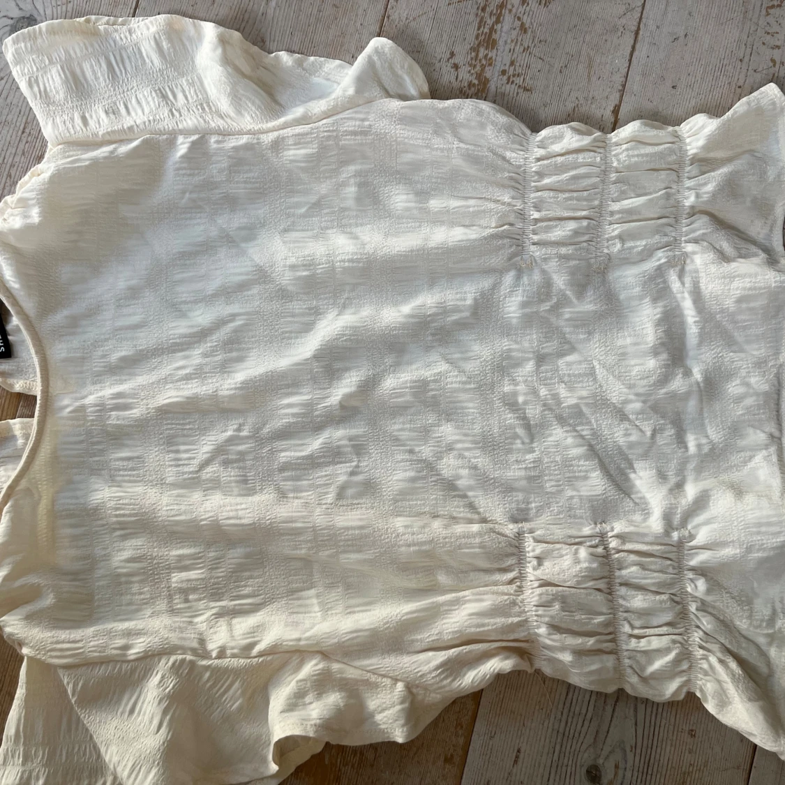 Vit topp med rynkdetaljer och volanger - 2