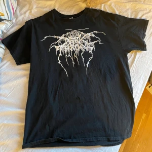 Svart band-tshirt (Darkthrone) med tryck - Svart darkthrone t-shirt med vit tryckt logga på framsidan och stor grafisk baksida med texten 'As Wolfs Among Sheep We Have Wandered'. Klassisk passform och rund hals. Perfekt för dig som gillar metal och vill sticka ut. Strl L men passar även M om man gillar oversized. OBS tröjan har haft ett hål men det är fixat (bild 3)