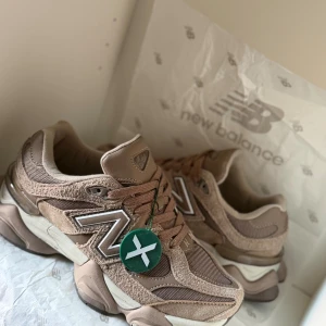 New Balance 9060PB sneakers brun - Säljer ett par New Balance 9060 brun färg med storlek 40 jag köpte från stock X och taggen är kvar. Det är liten för mig så därför säljer jag. Det finns kartongen men det är skadadt då det går inte använda längre
