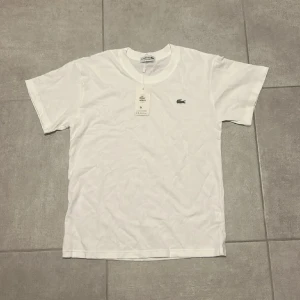 Lacoste T-Shirts - Uppgradera din garderob med två tidlösa klassiker från Lacoste! Dessa T-shirts kombinerar ren design, hög kvalitet och den ikoniska krokodil-loggan.