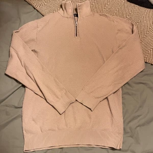Beige half zip tröja från Dressmann - Snygg beige half zip tröja från Dressmann i storlek M. Tröjan har ribbstickade muddar vid ärmslut och nederkant vilket ger en clean look. Perfekt för dig som gillar stilrena och bekväma tröjor!