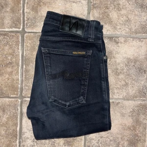 Nudie jeans  - Säljer ett par svarta Skinny Lin jeans från Nudie Jeans med smal passform och klassisk femficksdesign. Jeansen är tillverkade av 98% ekologisk bomull och 2% elastan för extra stretch. Midja 34cm, längd 103cm. Ifall det inte finns någon bild i annonsen där jag bär plagget så är det för att jag ej kan ha storleken heller passformen, så kolla måtten för storlek och googla på modellnamnet för passform 😉S4