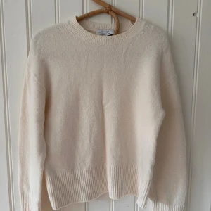  stickad tröja från & Other Stories - Säljer en cremevit stickad tröja från & Other Stories med rund hals och ribbade muddar vid ärmslut och nederkant. Tröjan har en clean och enkel design, perfekt för dig som gillar stilrena plagg. Mjuk och skön känsla, passar dig som vill ha en chill look.